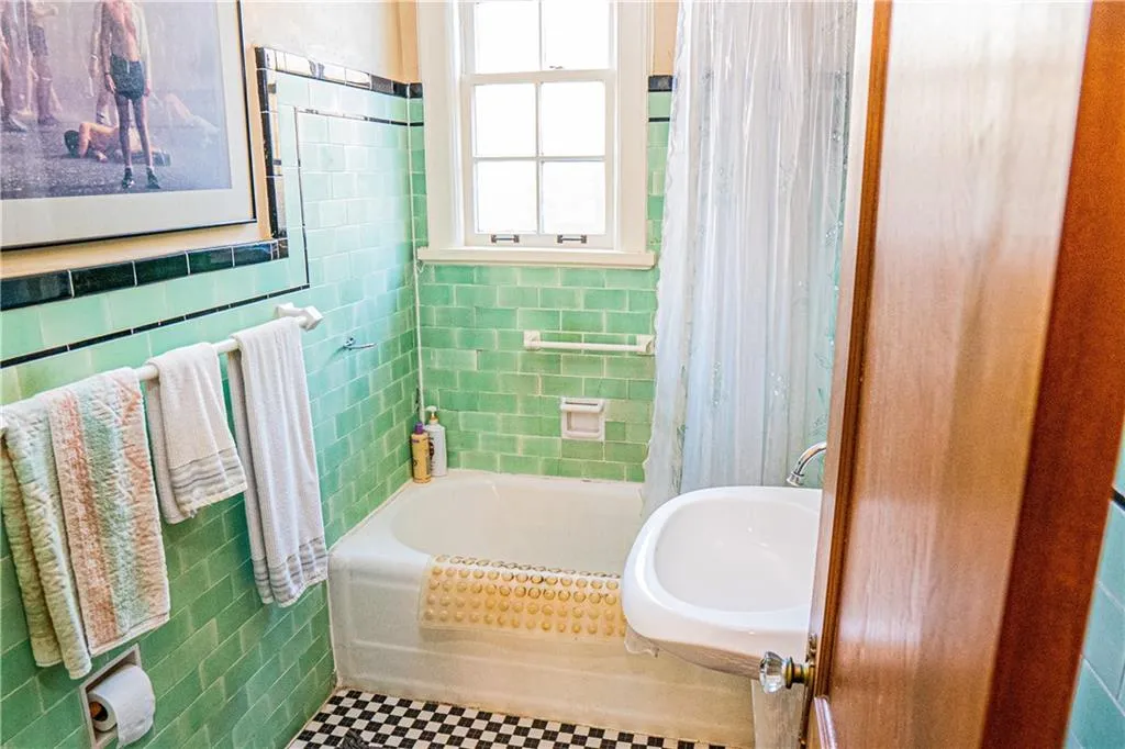 Bathroom with tile walls and shower / tub combo with curtain