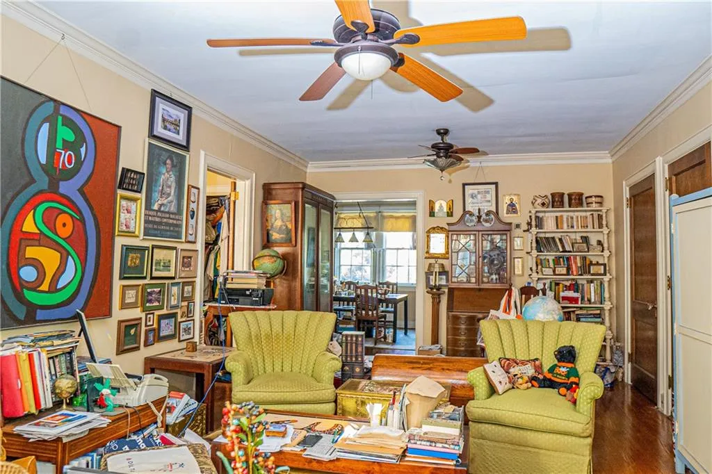 Sitting room featuring crown molding, wood finished floors, and a ceiling fan