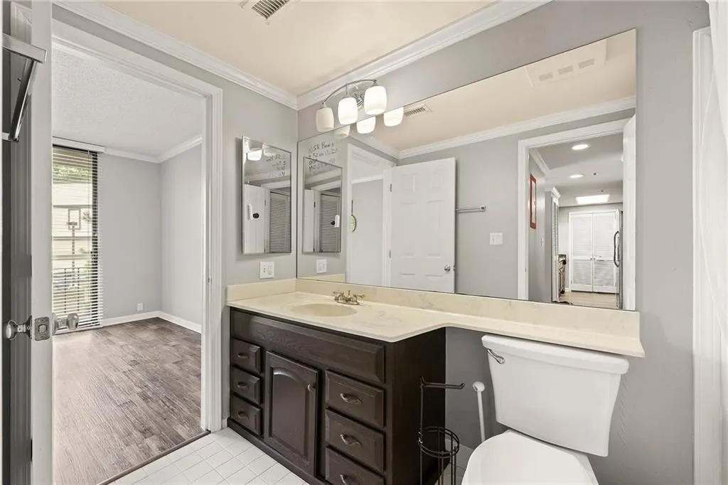 Bathroom featuring vanity, ornamental molding, tile patterned flooring, and recessed lighting