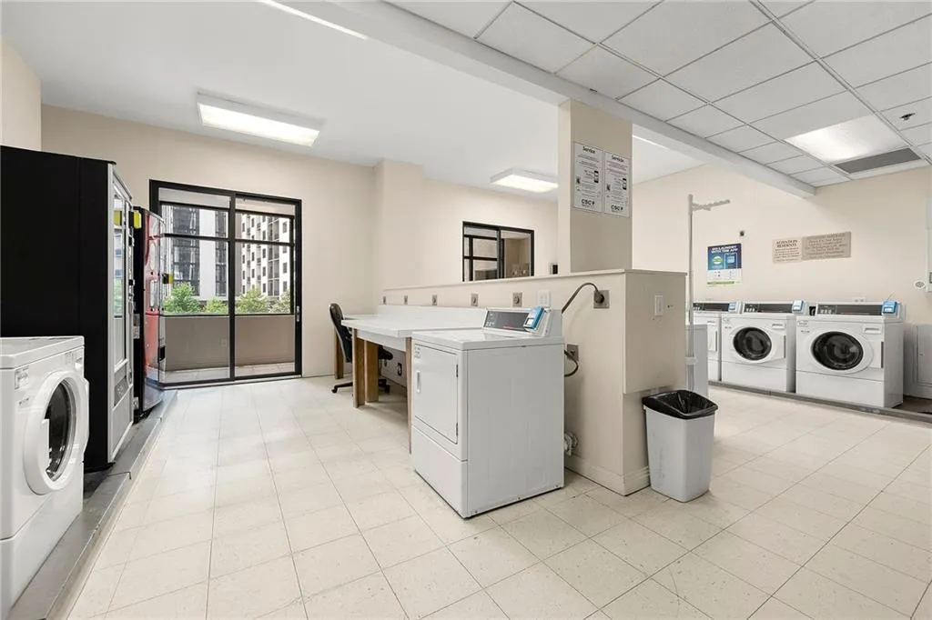 Community laundry room featuring washing machine and clothes dryer