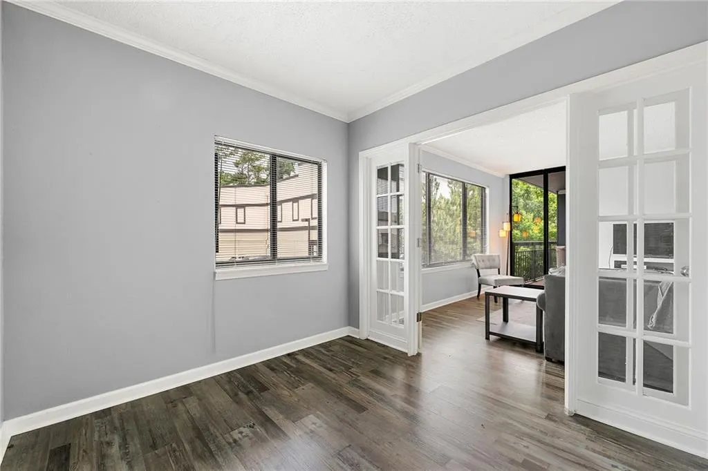 Unfurnished room featuring ornamental molding, dark wood-type flooring, french doors, and a textured ceiling