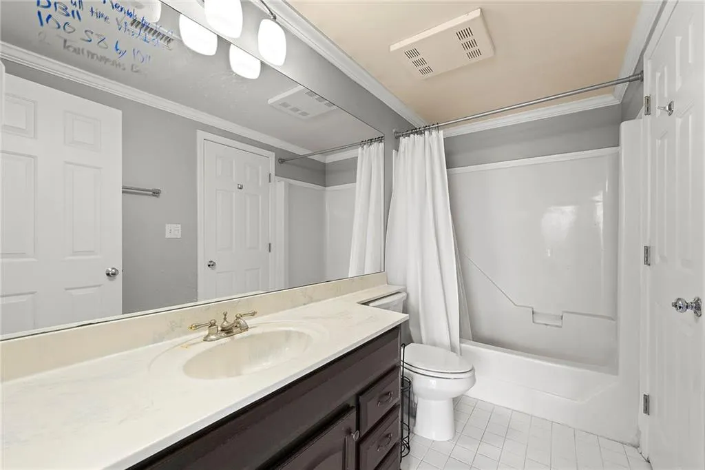 Full bath featuring vanity, tile patterned flooring, shower / bathtub combination with curtain, and crown molding