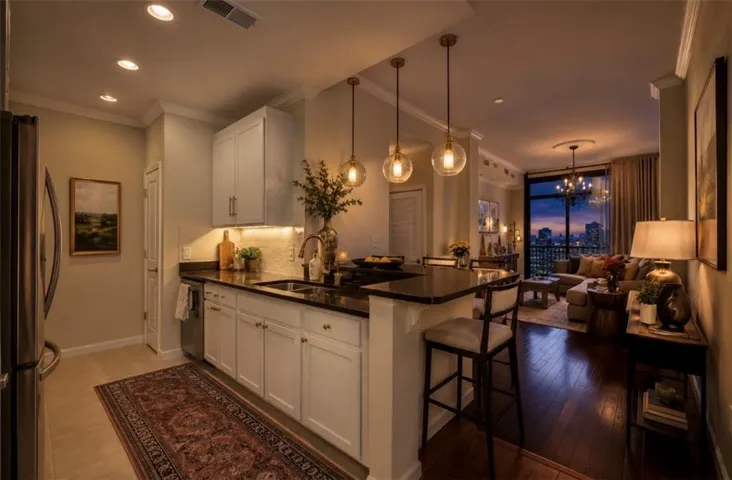 Kitchen featuring white cabinetry, dark countertops, a stainless steel refrigerator, and a stainless steel dishwasher