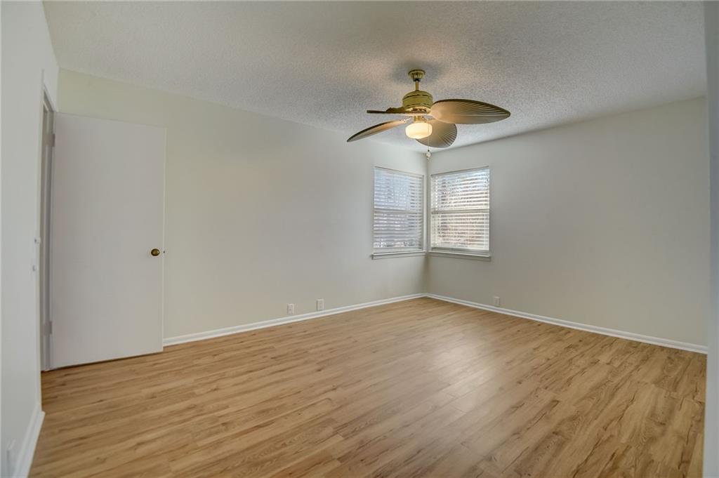 Spare room with light hardwood / wood-style floors, a textured ceiling, and ceiling fan