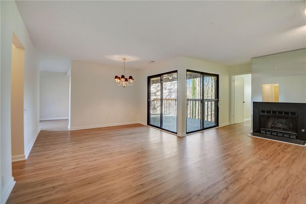 Unfurnished living room featuring a notable chandelier and light hardwood / wood-style floors