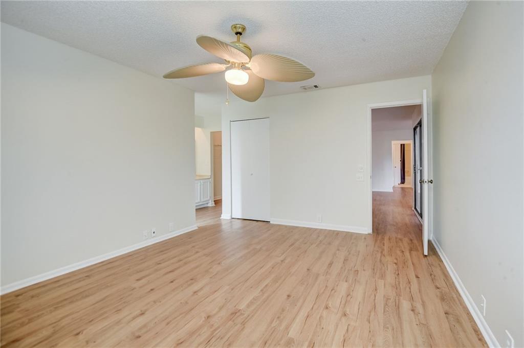 Empty room featuring light hardwood / wood-style floors, a textured ceiling, and ceiling fan