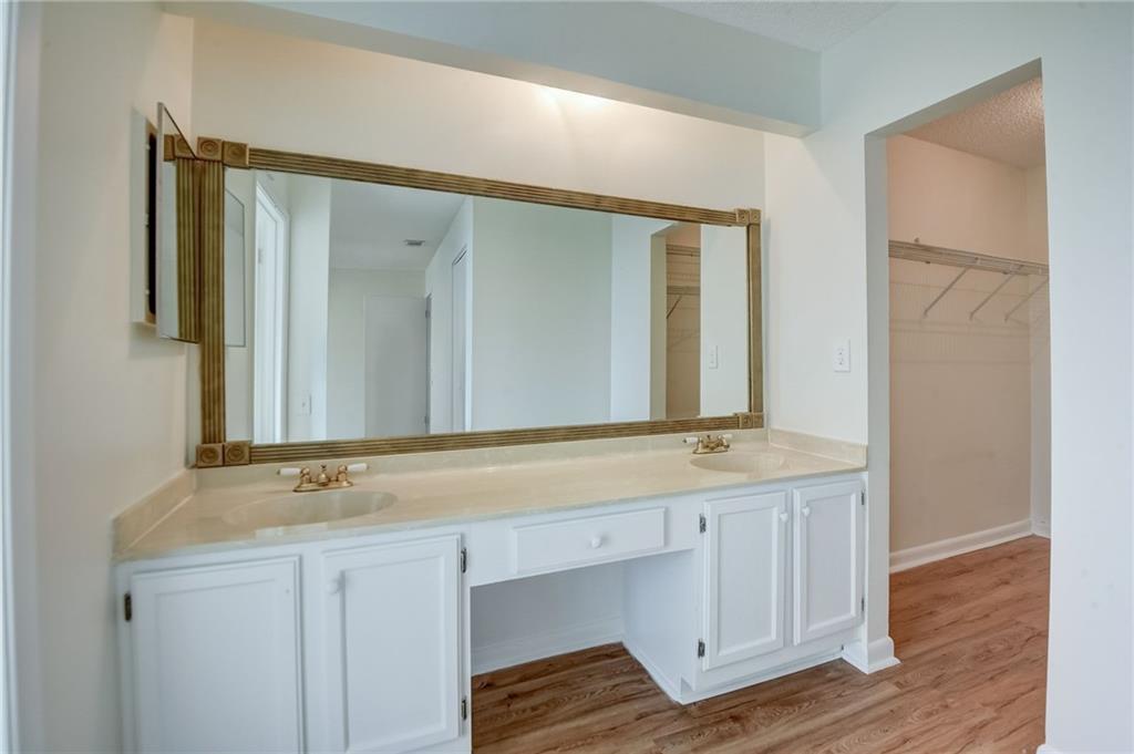 Bathroom with wood-type flooring, large vanity, and double sink