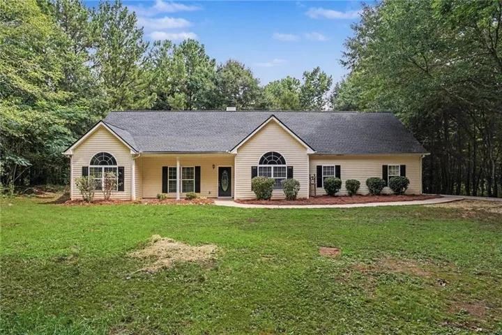Ranch-style residence featuring light-colored siding and a dark shingle roof