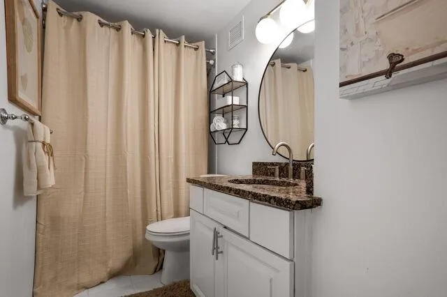 Full bathroom featuring vanity, tile patterned flooring, and curtained shower