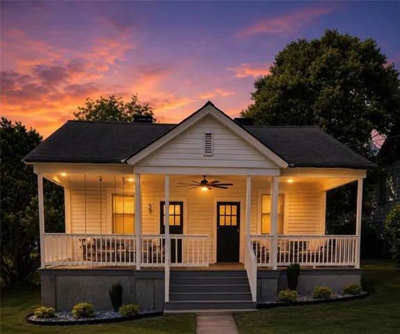 Charming single-story residence with a prominent front porch featuring white railings and a dark gray floor
