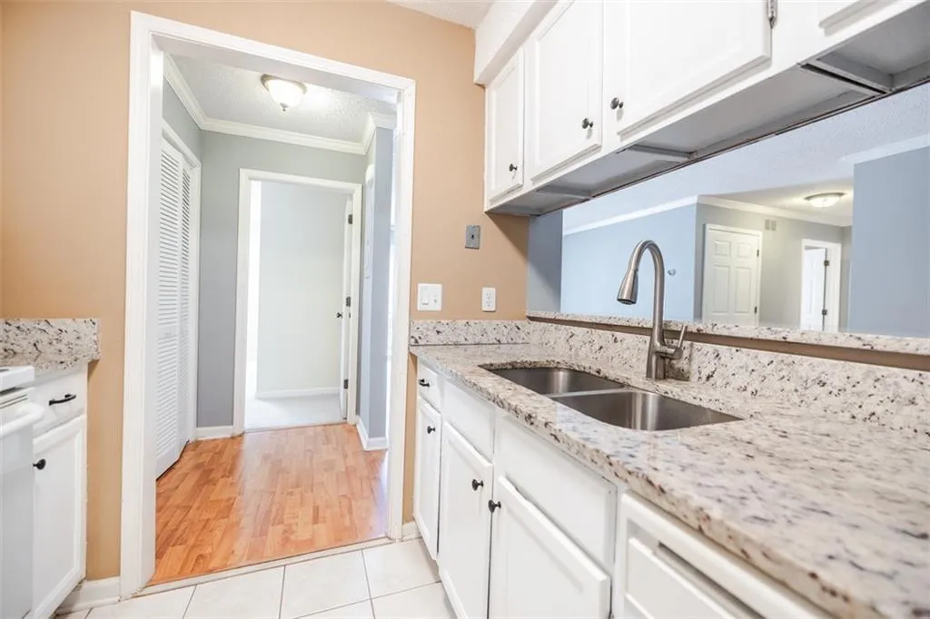 Granite countertops, white cabinets and views to the living and dining areas.