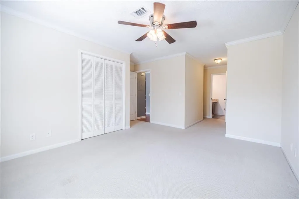 The primary bedroom features carpet, 2 closets and en suite bath with walk-in shower.