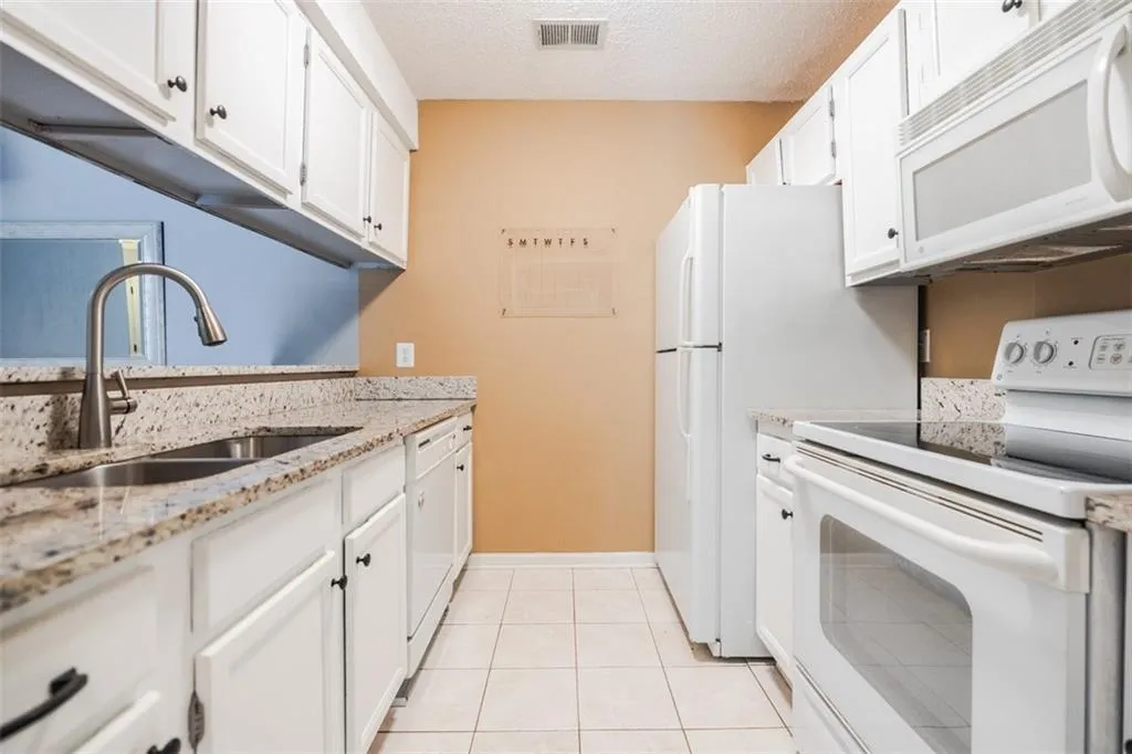 The kitchen features a white appliance package that blend with the white cabinets.