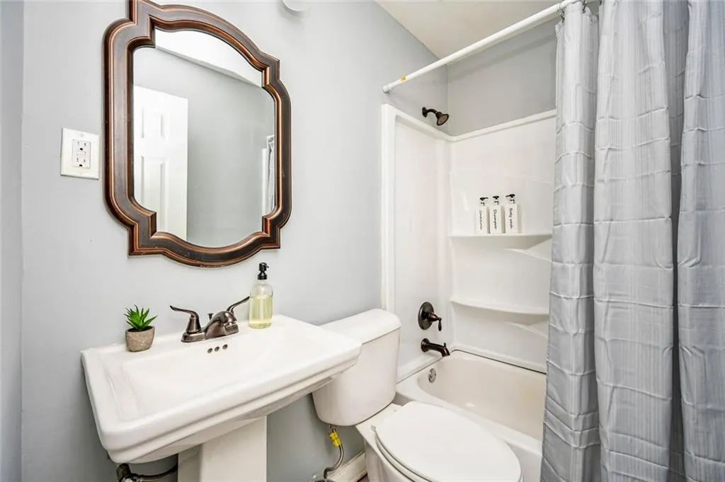 Full bath featuring shower / tub combo and toilet