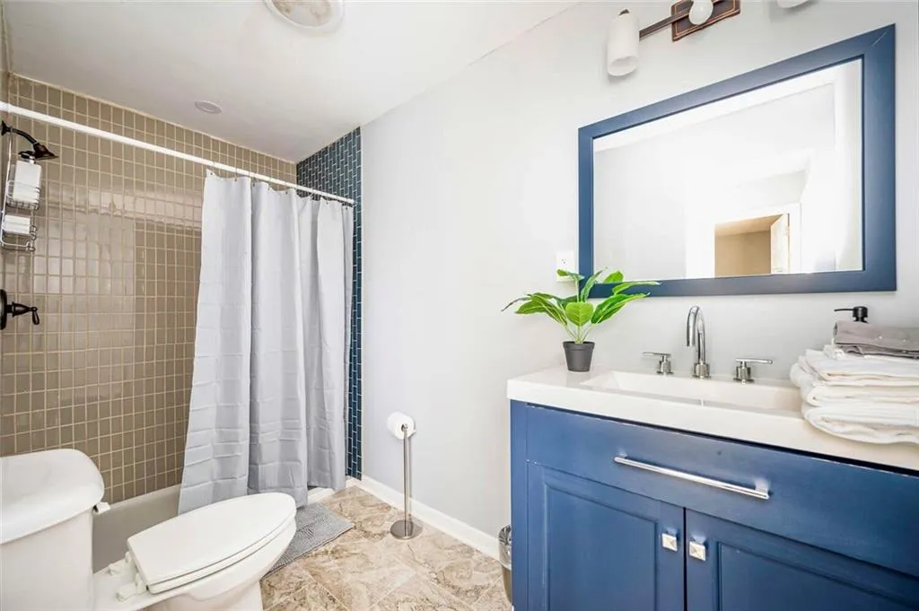 Bathroom featuring tiled shower and vanity