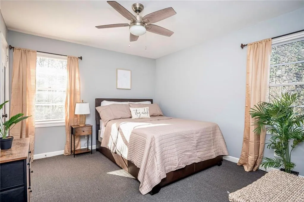 Bedroom with dark carpet and ceiling fan