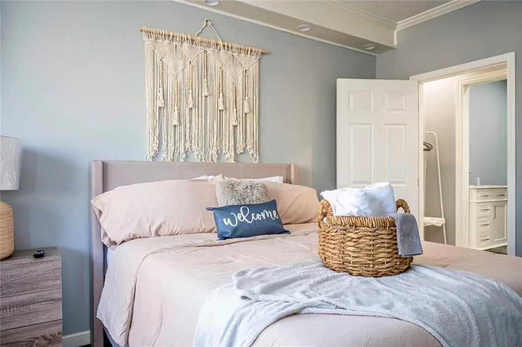 Bedroom featuring connected bathroom and crown molding