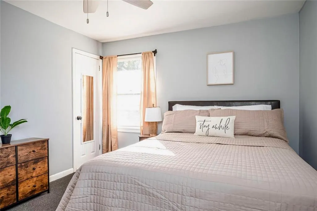 Bedroom with dark colored carpet and ceiling fan