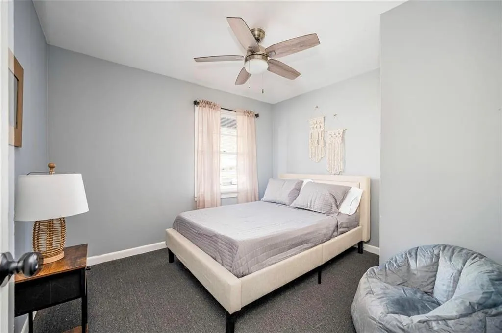 Carpeted bedroom with baseboards and a ceiling fan