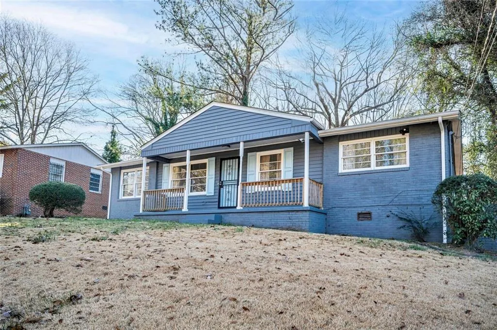 View of front of house with covered porch, crawl space, and brick siding