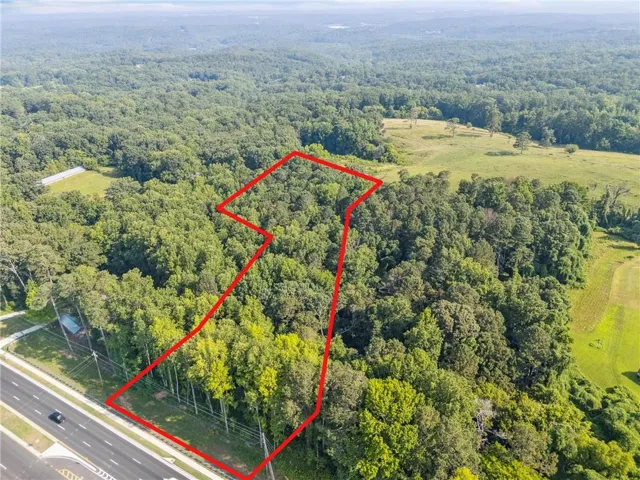 Expansive wooded lot featuring mature trees and direct road frontage