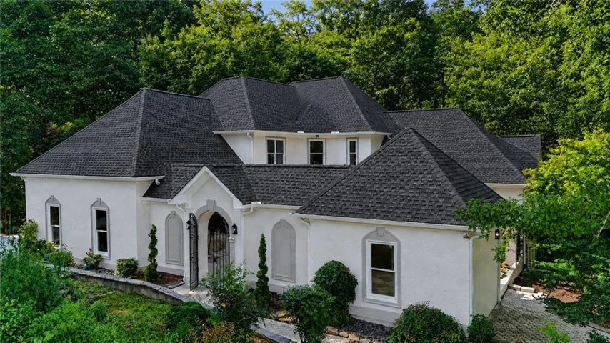 White stucco exterior with a dark shingle roof