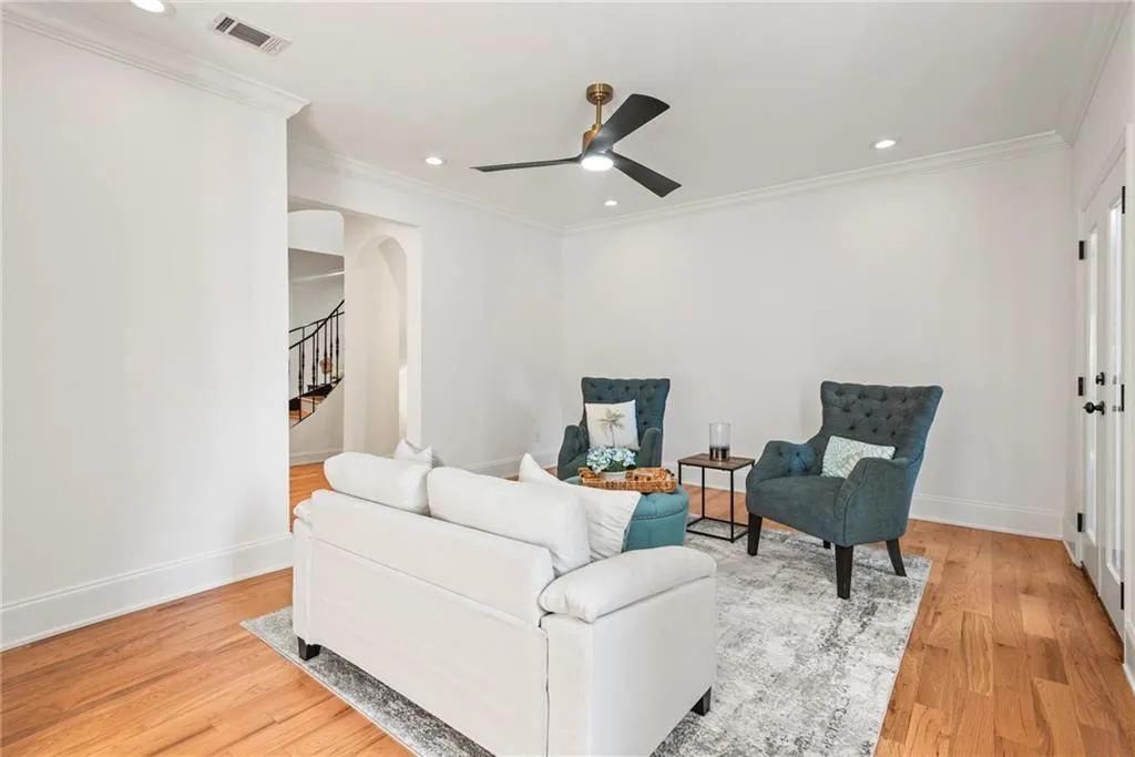 Living room with crown molding, light hardwood / wood-style flooring, and ceiling fan