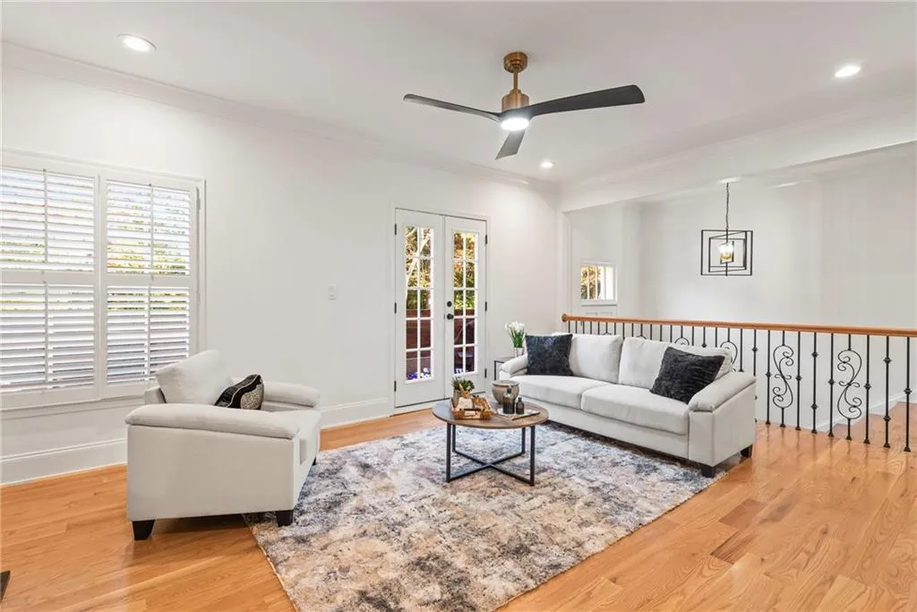 Living room with french doors, light wood-type flooring, ceiling fan, and crown molding