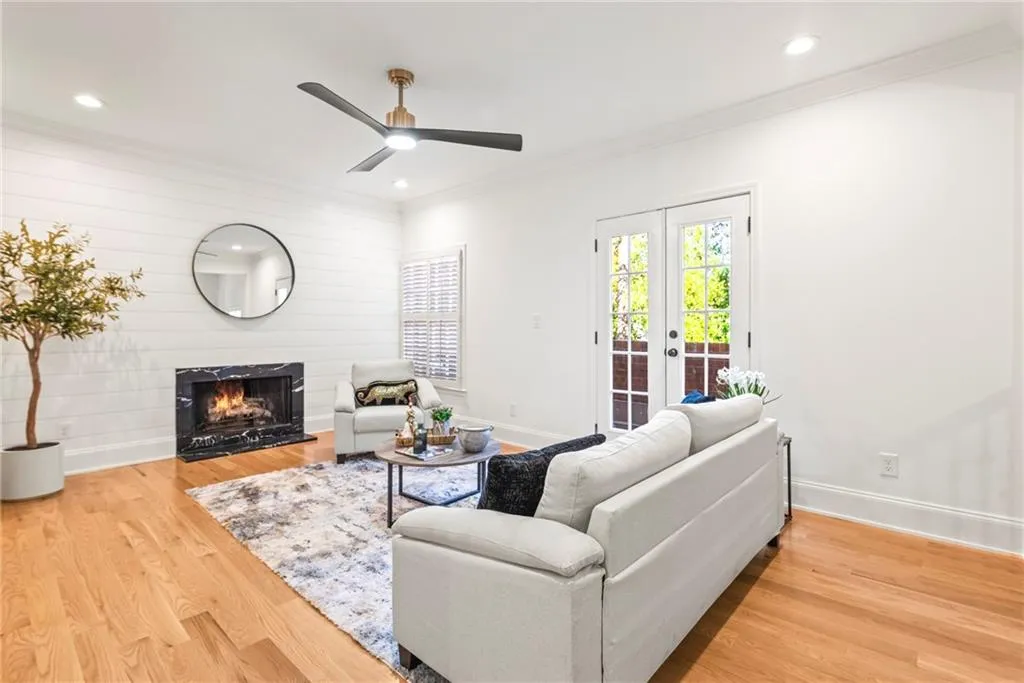 Living room with hardwood / wood-style floors, french doors, crown molding, and ceiling fan