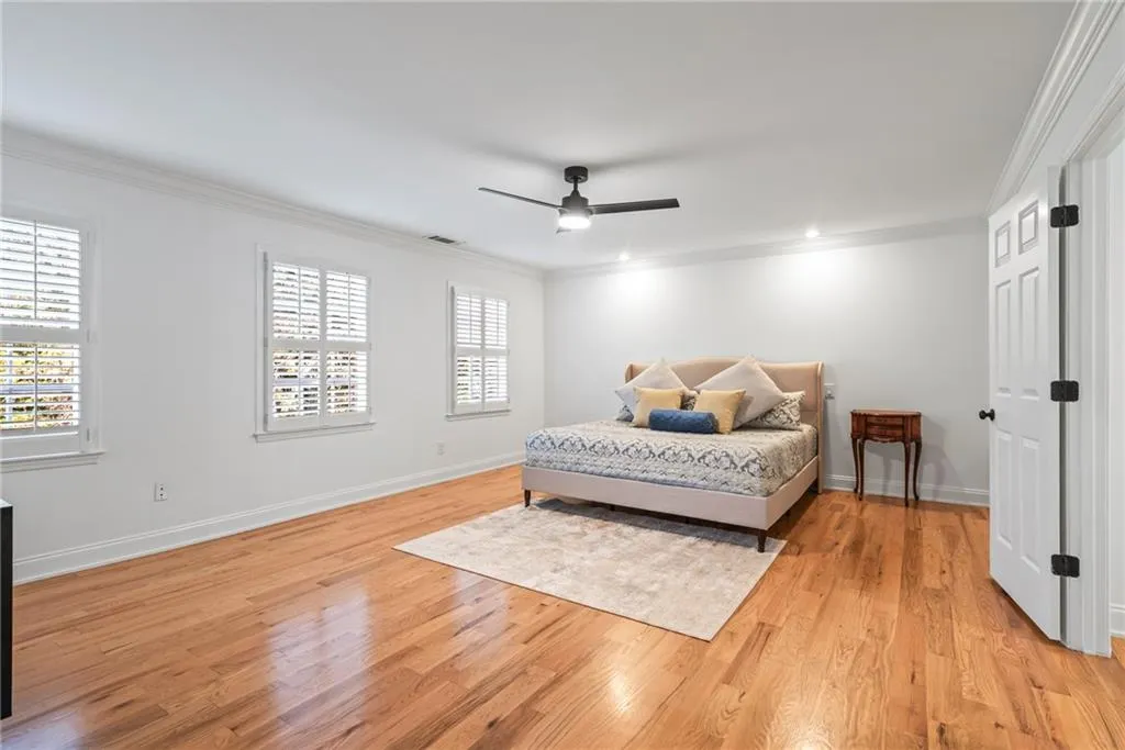 Bedroom featuring light wood-type flooring, ceiling fan, and crown molding
