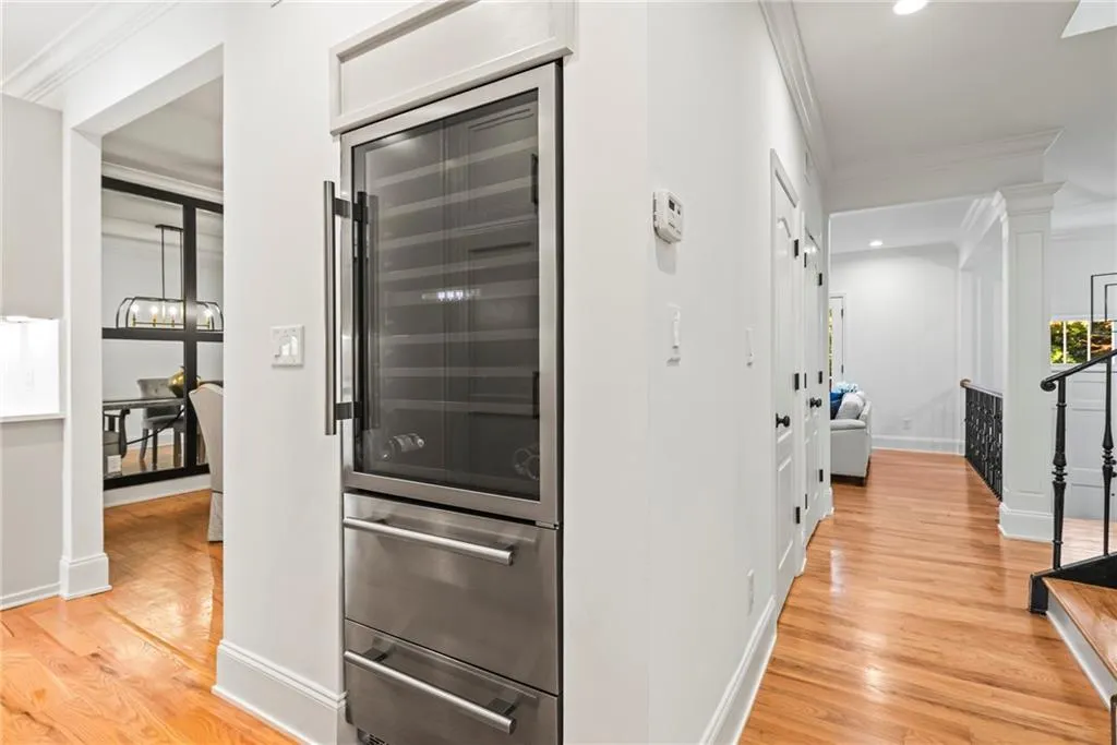 Kitchen with crown molding, light hardwood / wood-style flooring, beverage cooler, and an inviting chandelier