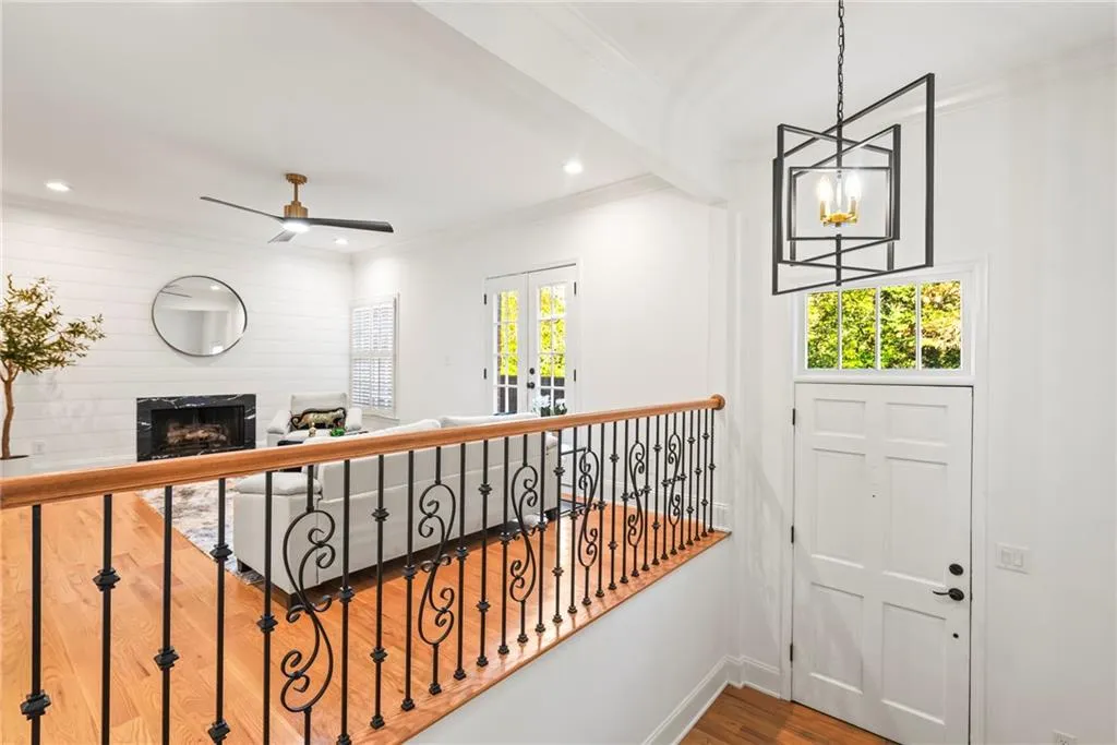 Hall featuring crown molding, wood-type flooring, and an inviting chandelier