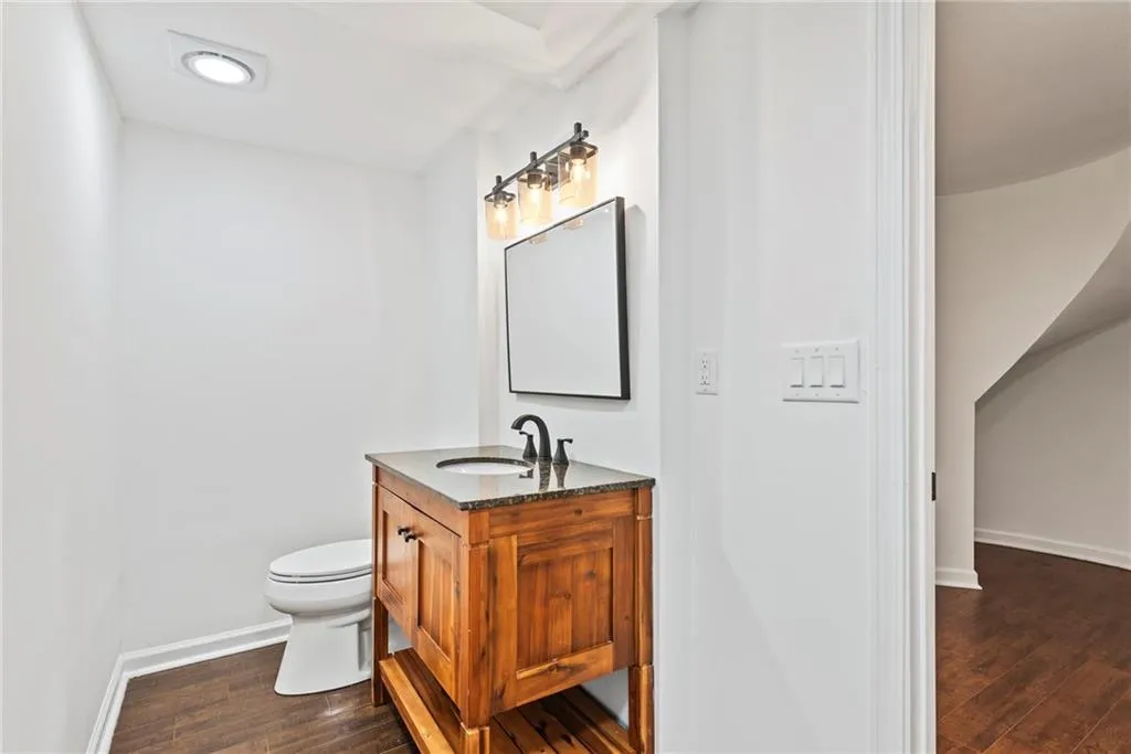 Bathroom with hardwood / wood-style floors, vanity, and toilet