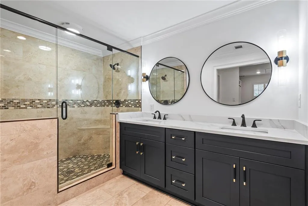 Bathroom with tile patterned floors, vanity, a shower with shower door, and crown molding