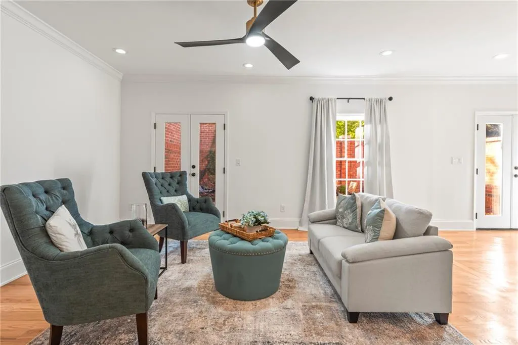 Living room with french doors, light hardwood / wood-style flooring, ceiling fan, and ornamental molding