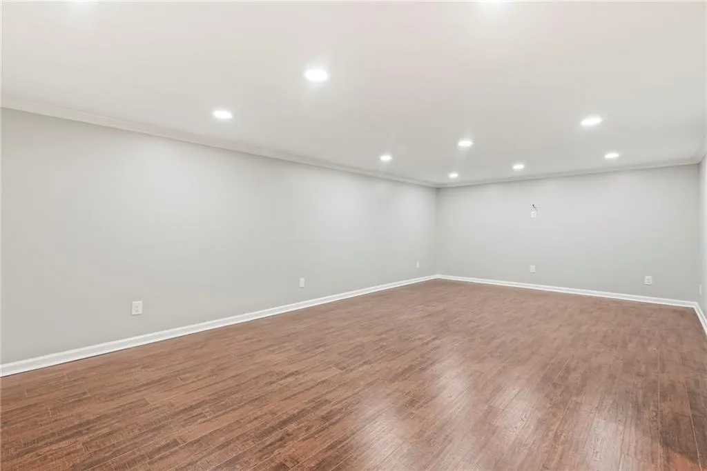 Spare room featuring hardwood / wood-style flooring and crown molding