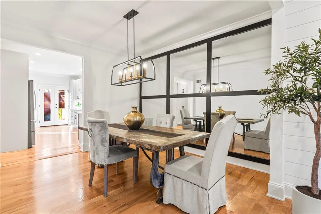 Dining area with light wood-type flooring, ornamental molding, and french doors