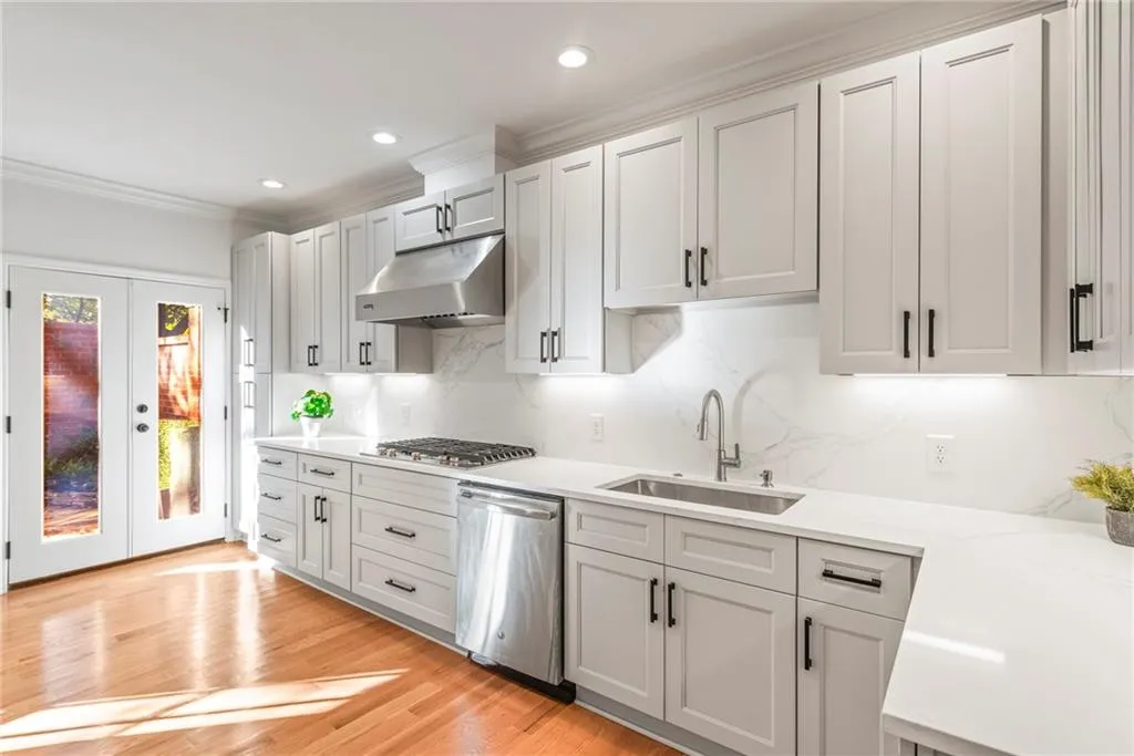 Kitchen featuring decorative backsplash, french doors, light wood-type flooring, stainless steel appliances, and sink