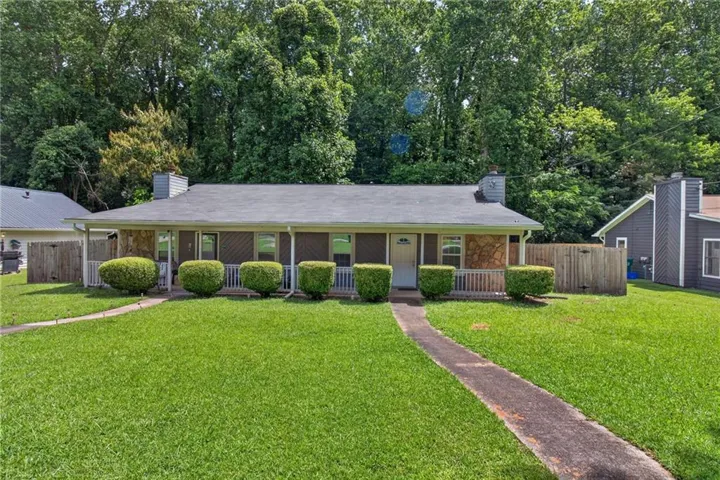 Front exterior with a covered porch, stone facade accents, and a sidewalk leading to the entrance
