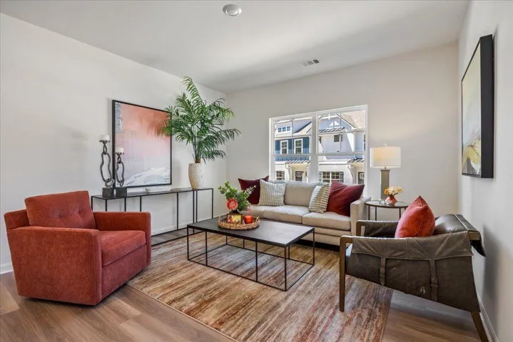 Recessed ceiling lighting, wood-finish flooring, large multi-pane window, white wall finishes, and a contemporary wall console table