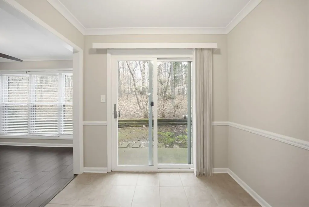 The kitchen opens onto a cozy patio overlooking peaceful wooded views-perfect for morning coffee or relaxing evenings