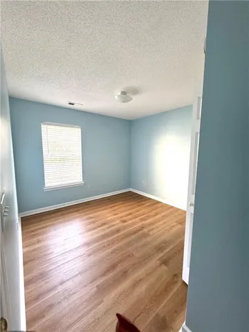 Wood-finish flooring with white baseboards