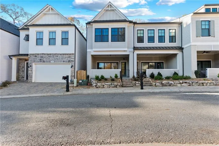Contemporary exterior with a prominent gable, stone facade, and integrated garage