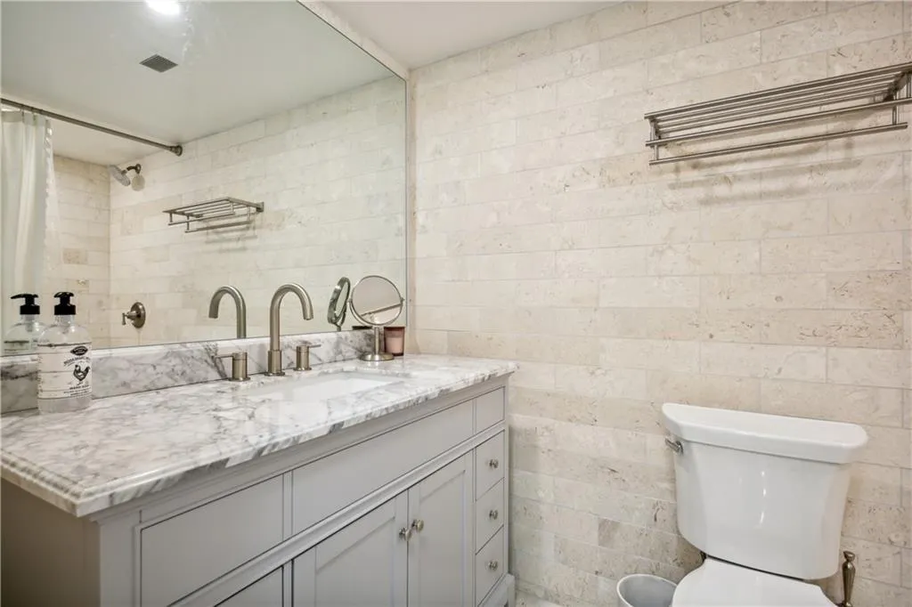 Spa-inspired bathroom featuring a marble-topped double vanity with dual vessel sinks, polished chrome faucetry, and soft-close cabinetry