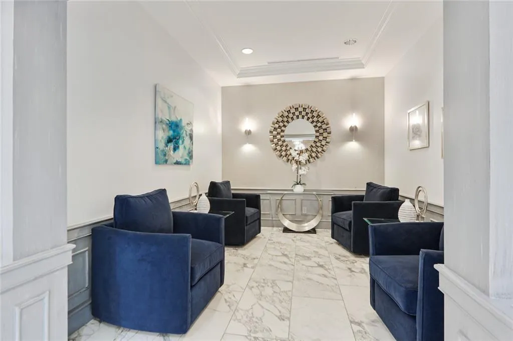 Marble-finish flooring, wainscoting details, recessed lighting, wall sconces, and crown molding
