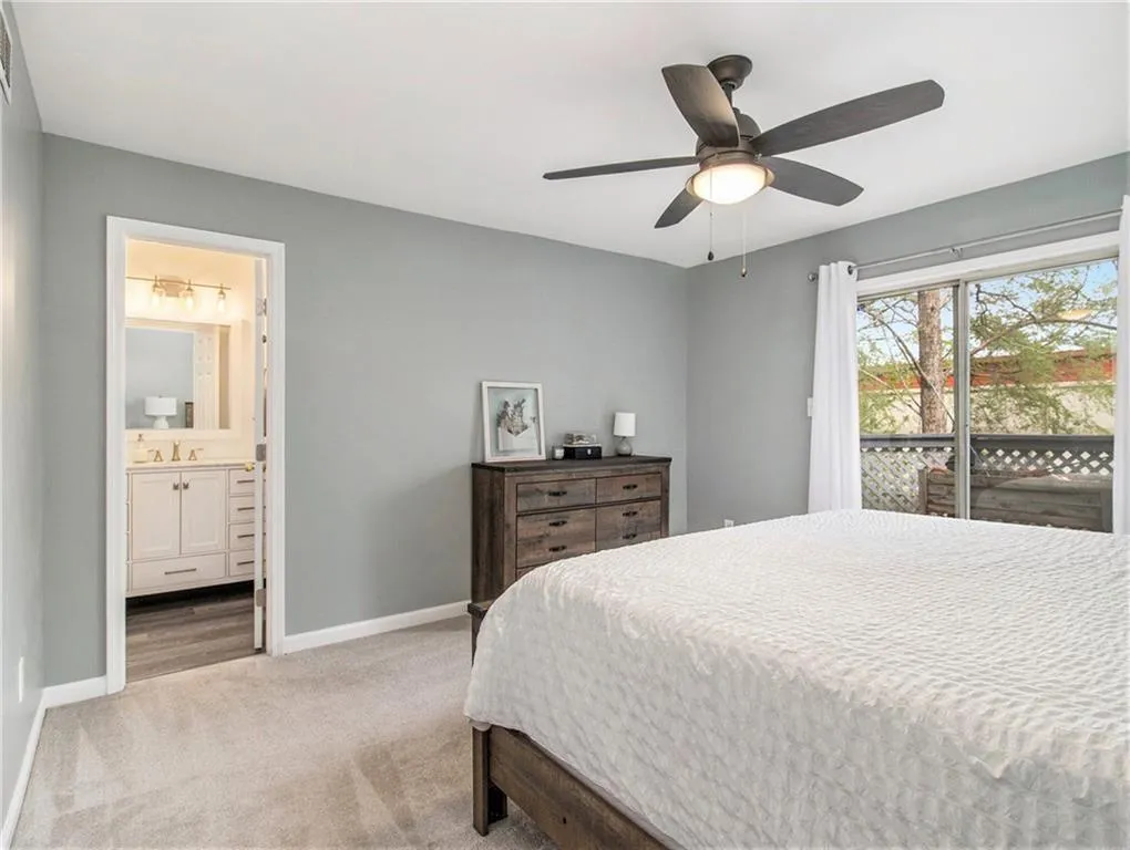 Plush carpeting, ceiling fan with integrated lighting, and a sliding glass door leading to an outdoor space