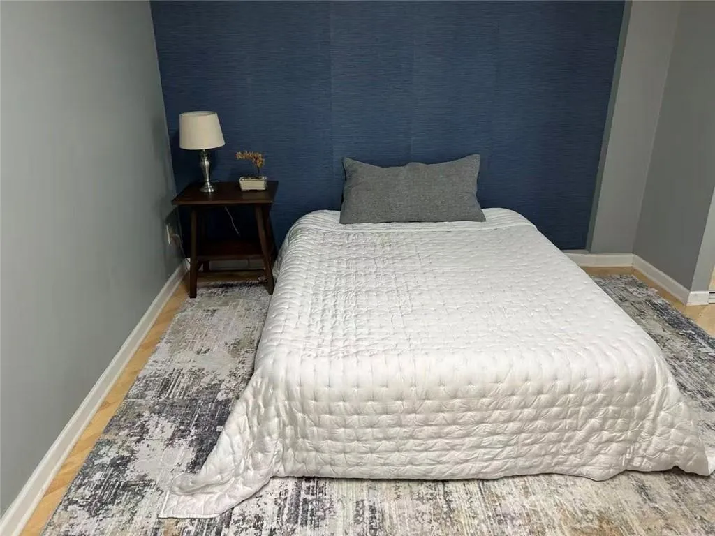 Light wood-finish flooring with a textured accent wall