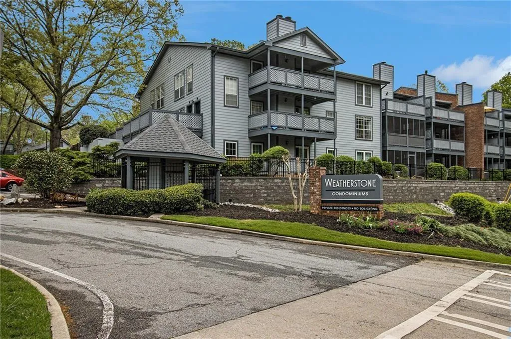 Condominium community with a multi-level building, multiple private balconies, and a stone-clad entry wall