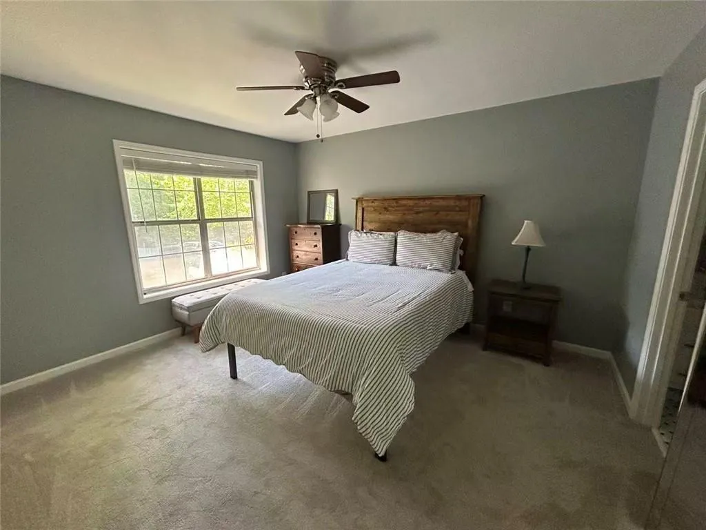 Carpeted room with a ceiling fan, a window, and painted walls