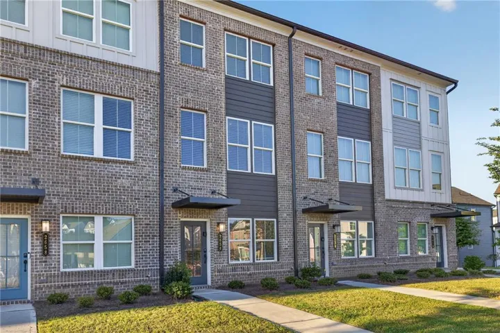Three-story exterior featuring brick and horizontal siding